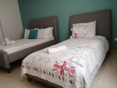 a bedroom with two beds with white sheets and red and white blankets at CC House Cartagena in Cartagena de Indias