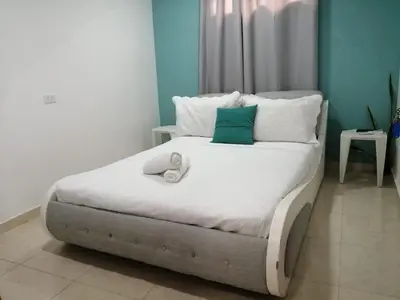 a bedroom with a large white bed with blue walls at CC House Cartagena in Cartagena de Indias