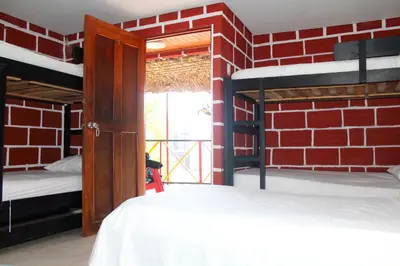 a room with two bunk beds and a brick wall at Hostal La Guaca in Cartagena de Indias