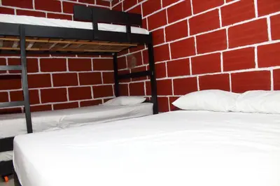 a bedroom with two bunk beds and a brick wall at Hostal La Guaca in Cartagena de Indias
