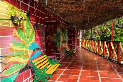 two benches sitting next to a wall with a mural at Hostal La Guaca in Cartagena de Indias