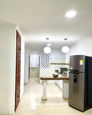 a kitchen with a table and a refrigerator at Casa Dimares in Cartagena de Indias