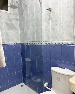 a blue tiled bathroom with a toilet and a shower at Casa Dimares in Cartagena de Indias