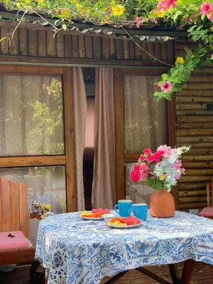 a table with plates and a vase of flowers on it at Laguna Rosa Glamping in Coveñas