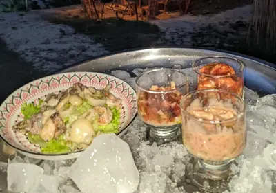 a table with a bowl of food and glasses of ice at Laguna Rosa Glamping in Coveñas