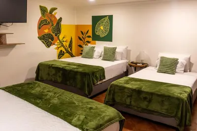 a room with two beds with green sheets at Candilejo Hotel Boutique in Cartagena de Indias