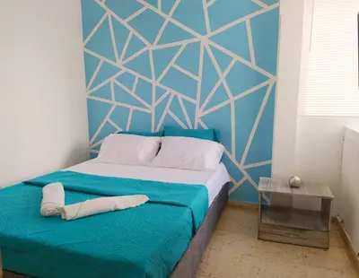 a bedroom with a bed with a blue wall at Espectacular Apartamento cerca al centro Histórico in Cartagena de Indias