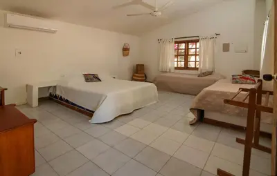 a large bedroom with two beds and a window at Cabana Canaima in Coveñas