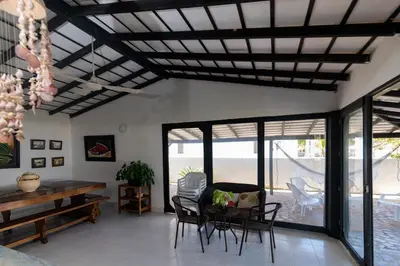 a living room with a table and chairs and windows at Cabana Canaima in Coveñas