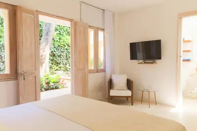 a bedroom with a bed and a tv and a chair at Casa Jaguar Hotel Boutique in Cartagena de Indias
