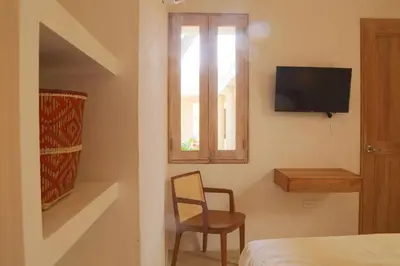 a bedroom with a chair and a television on a wall at Casa Jaguar Hotel Boutique in Cartagena de Indias