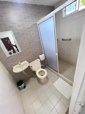 a bathroom with a shower and a toilet and a sink at Garden Home Hostal in Barranquilla