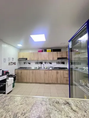 a large kitchen with wooden cabinets in a room at Garden Home Hostal in Barranquilla
