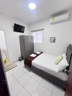 a bedroom with a bed and a television in it at Garden Home Hostal in Barranquilla