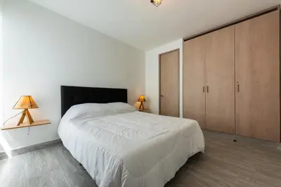 a white bedroom with a large bed and wooden cabinets at Nuevo apartamento en la zona norte de Cartagena in Puerto Tierrabaja
