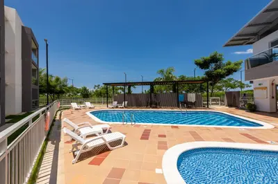 a swimming pool with lounge chairs next to a building at Nuevo apartamento en la zona norte de Cartagena in Puerto Tierrabaja