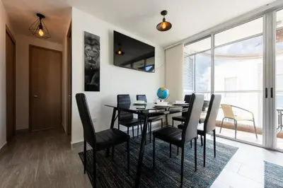 a dining room with a black table and chairs at Nuevo apartamento en la zona norte de Cartagena in Puerto Tierrabaja