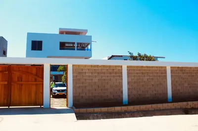 a house with a wooden gate and a garage at Cabaña Villas de Santa Veronica in Juan de Acosta