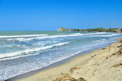 a beach with the ocean and the shoreline at Cabaña Villas de Santa Veronica in Juan de Acosta
