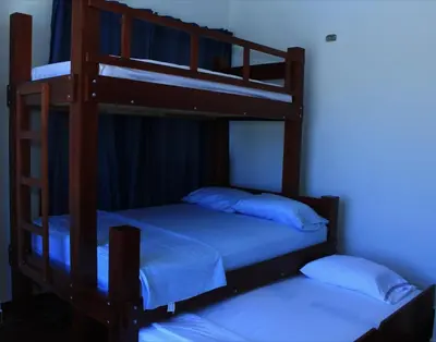 two bunk beds in a room with a blue light at Cabaña Villas de Santa Veronica in Juan de Acosta