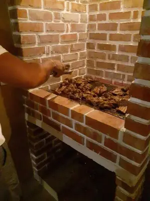 a person is making a brick oven in a brick wall at Casa Bustani Isla in Bocachica