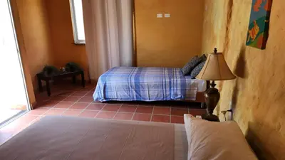 a bedroom with a bed and a lamp in a room at Casa Bustani Isla in Bocachica