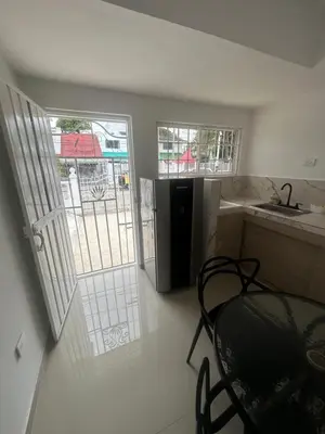 a small kitchen with a table and a refrigerator at Apartamento in Cartagena de Indias