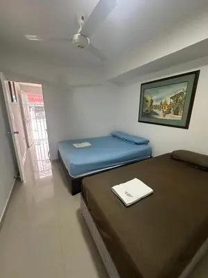 two beds in a small room with a window at Apartamento in Cartagena de Indias
