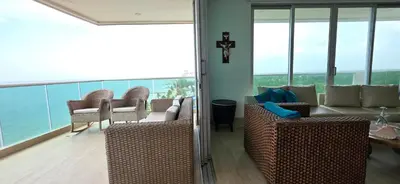 a living room with chairs and a couch and windows at Hermoso Apartamento frente al mar, 4 habitaciones - Apto 801 in Coveñas