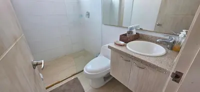 a bathroom with a sink and a toilet and a mirror at Hermoso Apartamento frente al mar, 4 habitaciones - Apto 801 in Coveñas