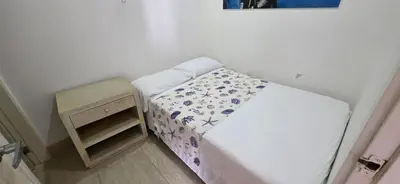 a small bedroom with a bed and a night stand at Hermoso Apartamento frente al mar, 4 habitaciones - Apto 801 in Coveñas