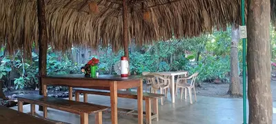 a wooden table and chairs in a pavilion at El Viejo del Mar in San Bernardo del Viento