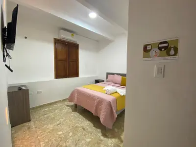 a small bedroom with a bed and a window at Casa Gran Fuente in Cartagena de Indias