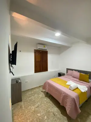 a bedroom with a bed and a tv on the wall at Casa Gran Fuente in Cartagena de Indias