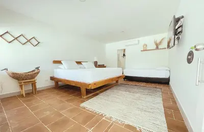 a bedroom with two beds and a rug at Quinta del Mar Crystal Beach in Tintipan Island
