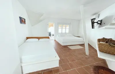 a white room with two beds in it at Quinta del Mar Crystal Beach in Tintipan Island