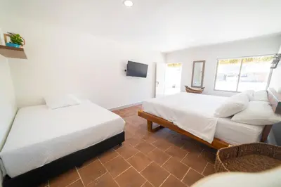 a bedroom with two beds and a television in it at Quinta del Mar Crystal Beach in Tintipan Island