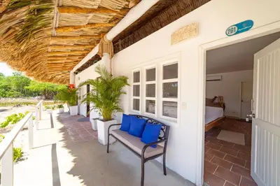 a porch with blue pillows and a bed at Quinta del Mar Crystal Beach in Tintipan Island