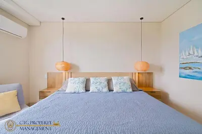 a bedroom with a blue bed with two pillows at Martinique Cartagena - Apartamentos A Corta Caminata De Playa Azul in Cartagena de Indias