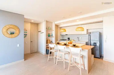 a kitchen with a table and chairs in a kitchen at Martinique Cartagena - Apartamentos A Corta Caminata De Playa Azul in Cartagena de Indias