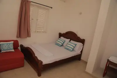a bed in a room with a window and a red couch at Club Camping Islamar in Baru