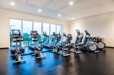 a gym with a row of treadmills and machines at Dreams Karibana Cartagena Golf & Spa Resort in Cartagena de Indias