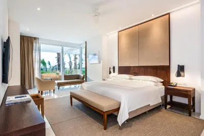 a bedroom with a large bed and a living room at Dreams Karibana Cartagena Golf & Spa Resort in Cartagena de Indias