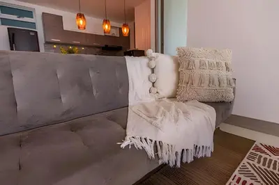 a couch with a pillow on it in a living room at Laurdhomes Palmetto Beach Sew View, Hot Water in Cartagena de Indias