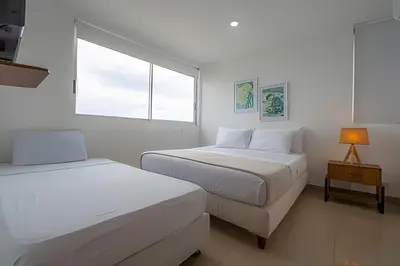 two beds in a white room with a window at LaurdHomes Palmetto Sea View, 2Rooms 2BTH Hot Ware in Cartagena de Indias