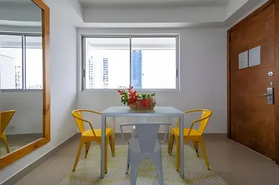 a dining room with a table and yellow chairs at LaurdHomes Palmetto Sea View, 2Rooms 2BTH Hot Ware in Cartagena de Indias