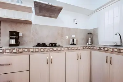 a white kitchen with white cabinets and a sink at Laurdhomes Duplex Old City, Plaza Santo Domingo in Cartagena de Indias