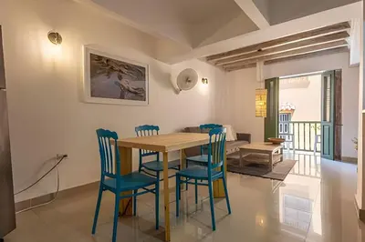 a dining room with a wooden table and blue chairs at Laurdhomes Duplex Old City, Plaza Santo Domingo in Cartagena de Indias