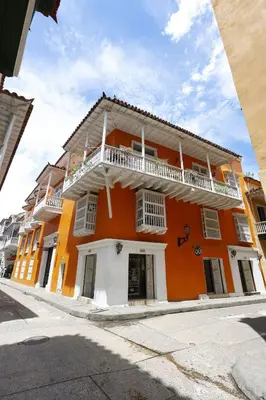 an orange and white building with a balcony at Laurdhomes Duplex Old City, Plaza Santo Domingo in Cartagena de Indias