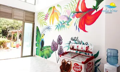 a coca cola store with a colorful mural on the wall at Arenillas del Mar in Tolú